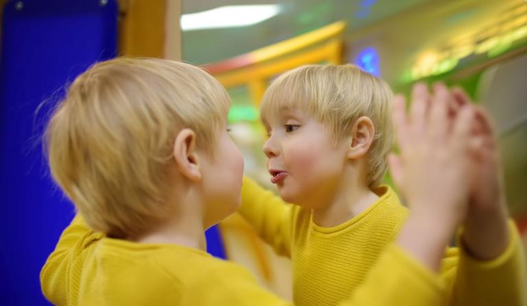 Dreng i gul trøje kigger sig i spejl
