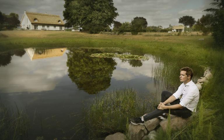 Jacob Mark sidder ved en sø