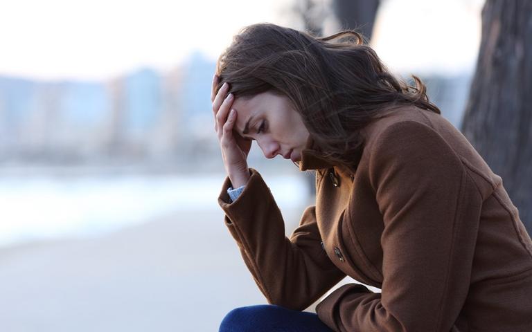 Stressramt kvinde sidder udenfor