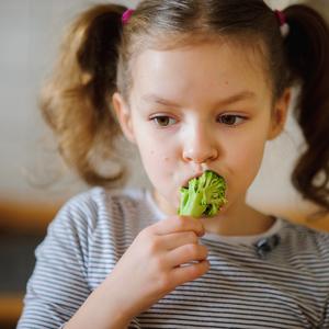 foto af barn, der spiser broccoli.