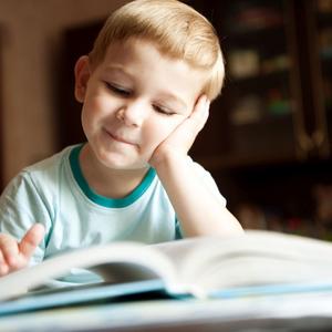 Foto af lille dreng, der kigger i en bog.