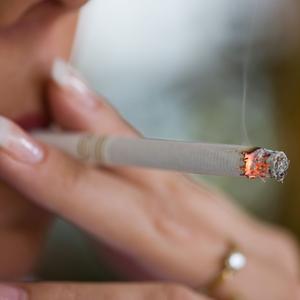 Ung kvinde ryger en cigaret