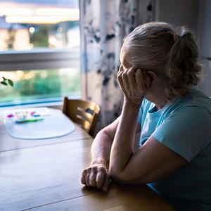 Kvinde sidder og kigger ud ad vinduet