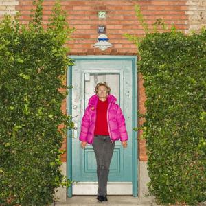 Økonom Birthe Larsen fotograferet foran blå dør