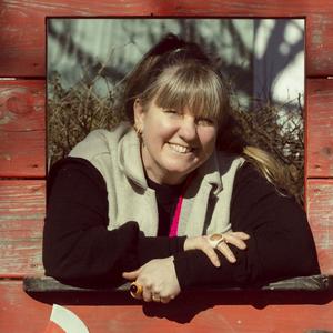 Pernille Geiker Howard kigger ud af et rødt legehus