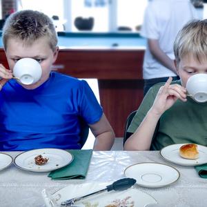 To drenge drikker te og stritter med lillefingrene