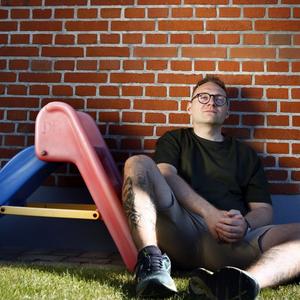 Pædagog Jimmy Knudsen sidder ved lille rutsjebane