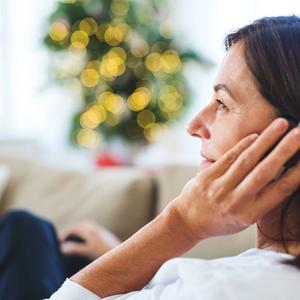 Kvinde lytter til podcast med lys i baggrunden