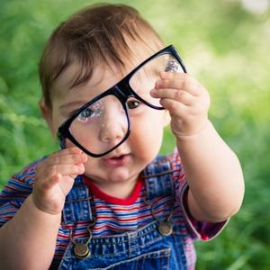 Lille barn sidder med briller