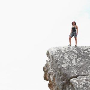 Kvinde står på toppen af bjerg
