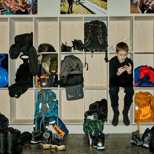 Dreng sidder alene i klub med sin telefon