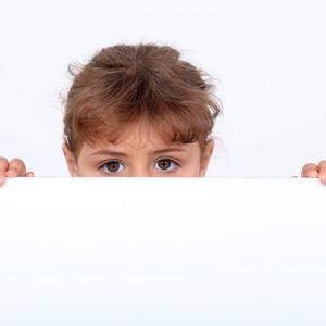 Barn kigger op over kanten af et bord