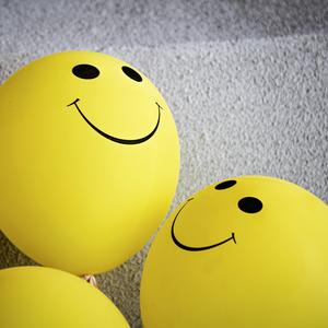 Gule balloner med smiley-ansigter på