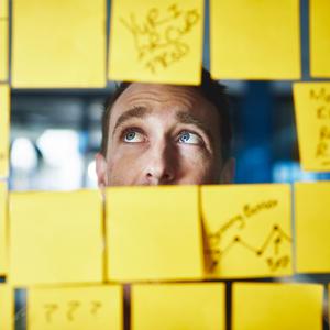mandlig leder og mange gule post-it-sedler; for mange opgaver