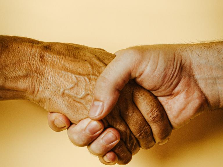 håndtryk med ung og ældre hånd