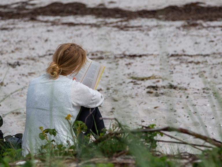 Kvinde læser ved stranden