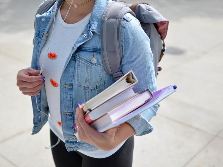 pædagogstuderende med rygsæk og bøger