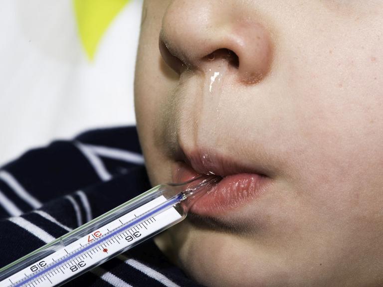 Barn med snotnæse og termometer i munden