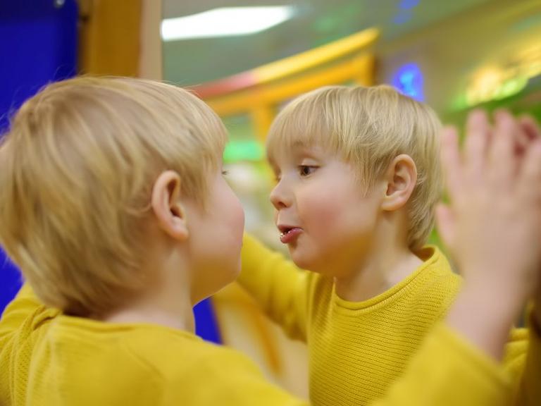 Dreng i gul trøje kigger sig i spejl