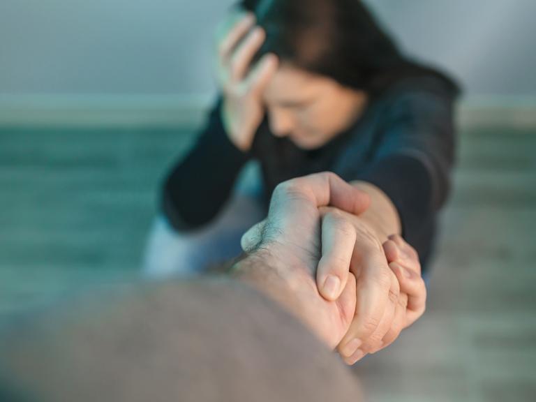 mand rækker en hånd til stresset kollega på gulvet