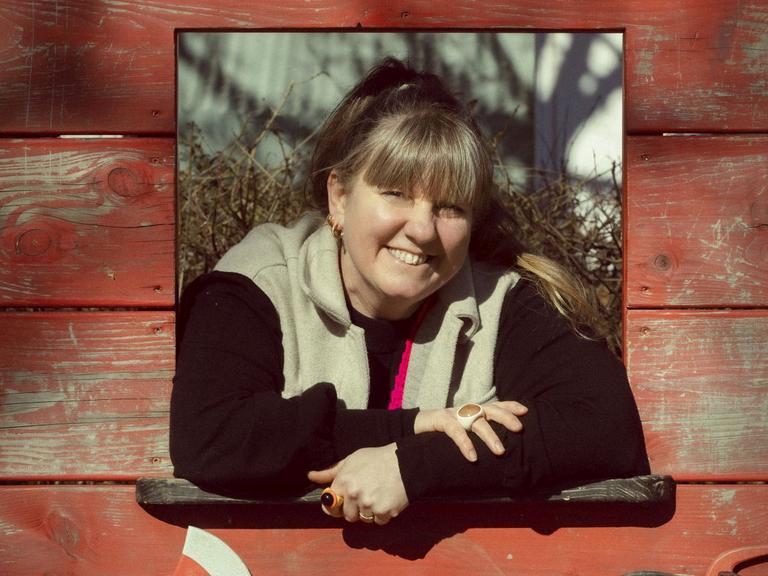 Pernille Geiker Howard kigger ud af et rødt legehus