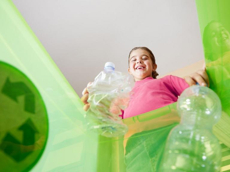 Pige ser ned i kasse til opsamling af plast