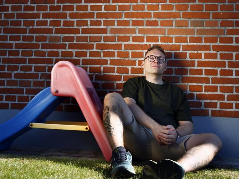 Pædagog Jimmy Knudsen sidder ved lille rutsjebane