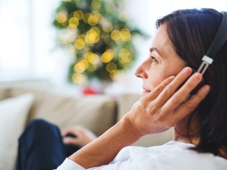 Kvinde lytter til podcast med lys i baggrunden