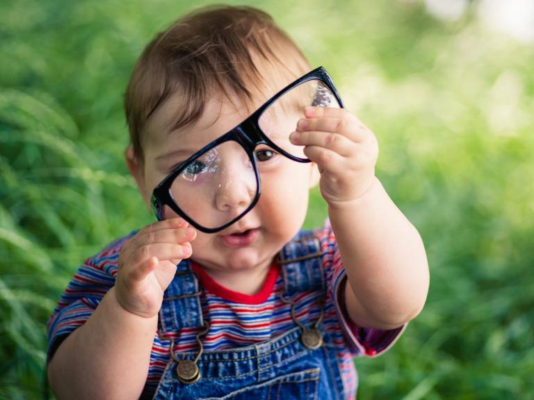 Lille barn sidder med briller