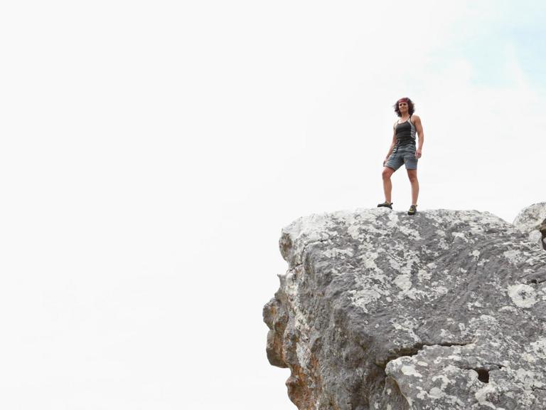 Kvinde står på toppen af bjerg