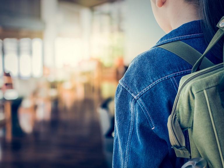 pige med skoletaske i klasselokale