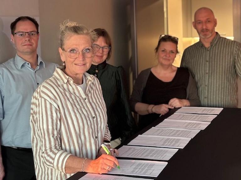 Foto af Birgitte Conradsen, der skriver under