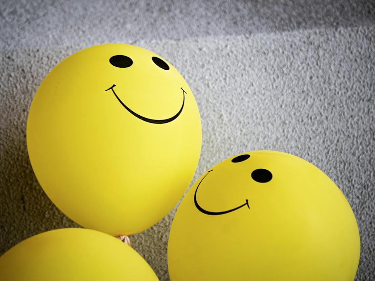 Gule balloner med smiley-ansigter på