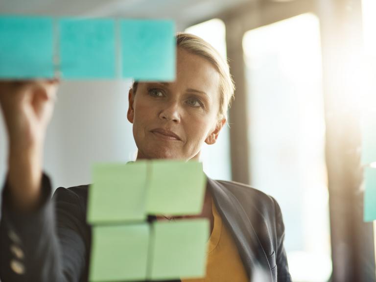 kvindelig leder og post-it-sedler; planlægger