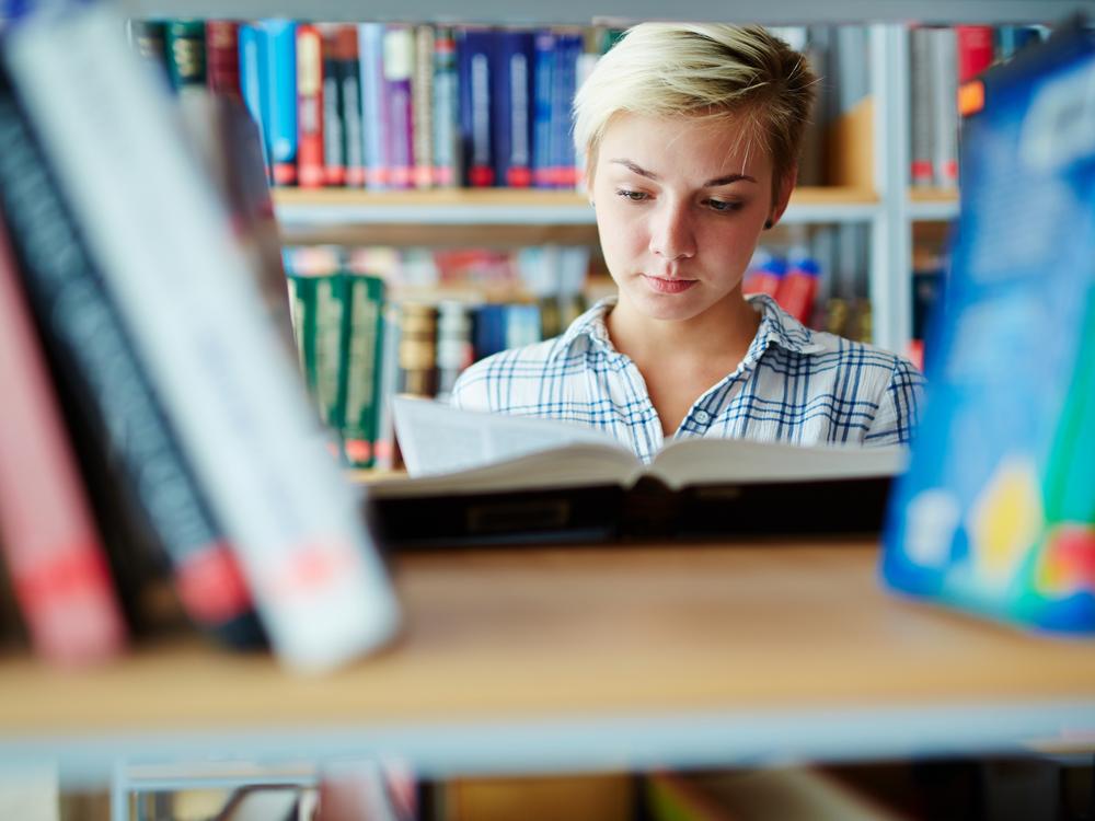 Kvindelig pædagogstuderende på et bibliotek