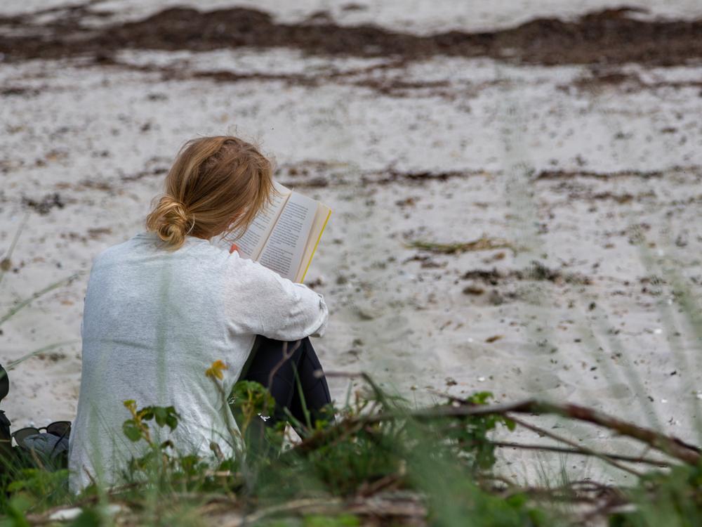 Kvinde læser ved stranden