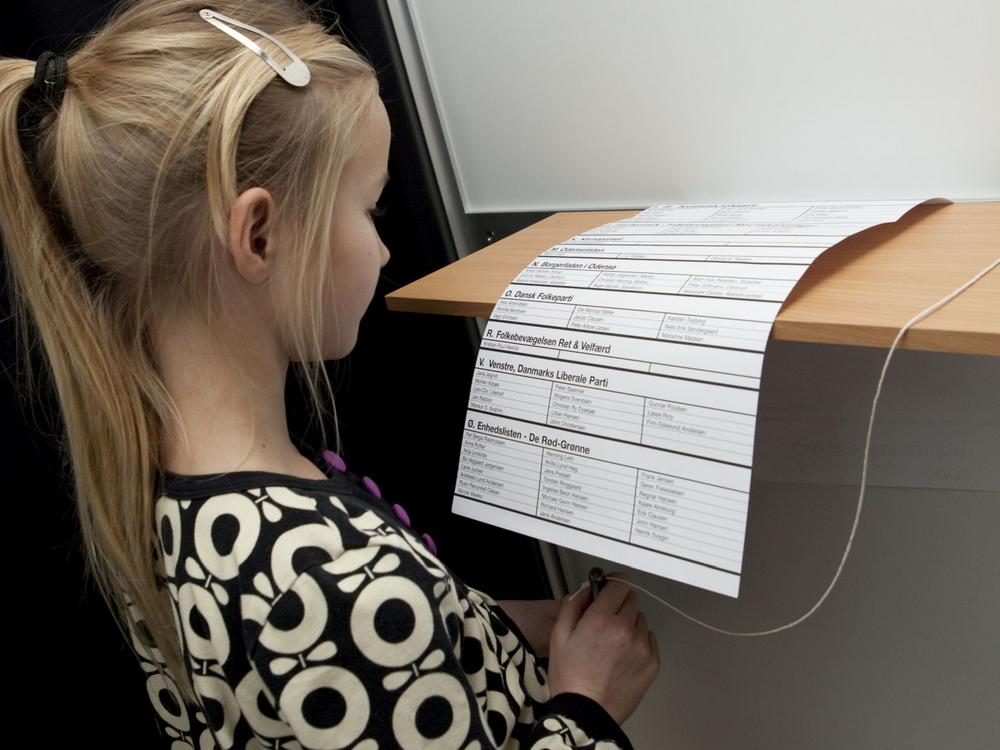 Pige med valgseddel i stemmeboks
