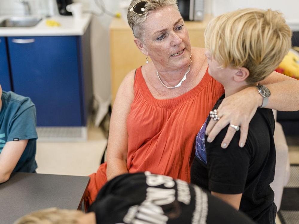 Pædagog Birgitte Hørup Andersen står med armen om et barn