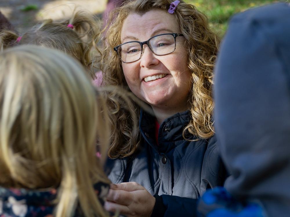 Pædagog Majbritt Degn Kallehauge smiler, omringet af børn