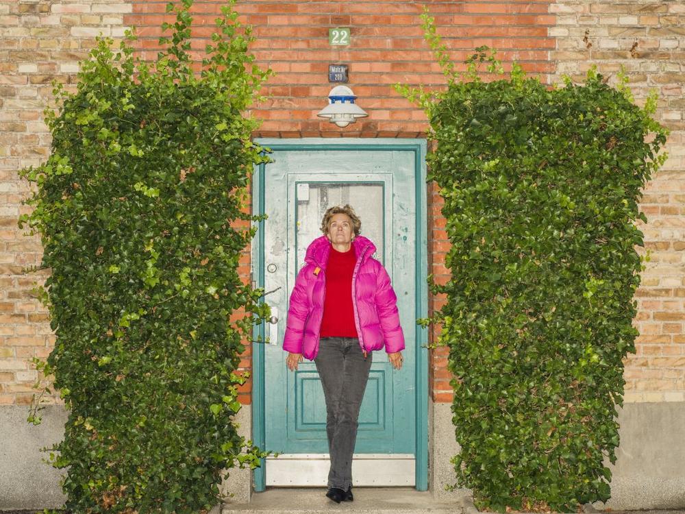 Økonom Birthe Larsen fotograferet foran blå dør