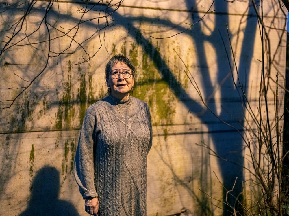 Pædagog Amalie Dorthe Pedersen står foran en væg. Skyggen af et træ omkranser hende.
