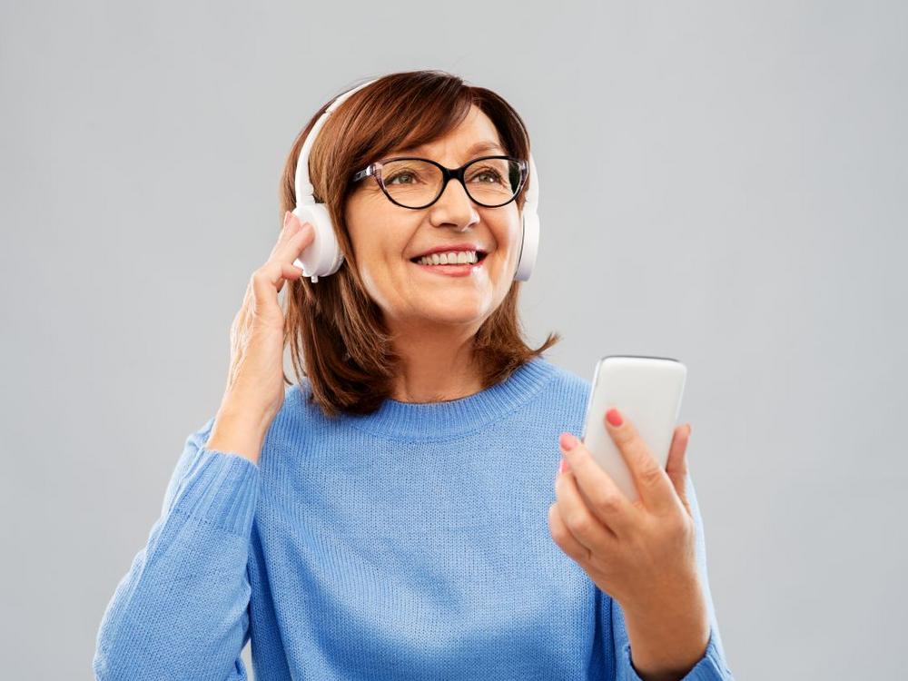 Kvinde i blå sweater lytter til podcast