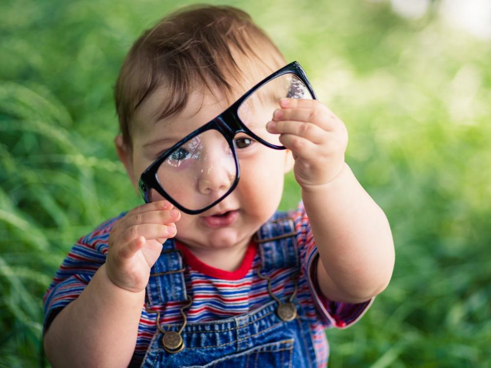 Lille barn sidder med briller