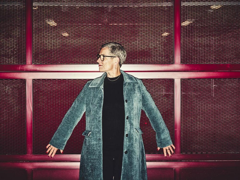 Psykolog og forfatter Rikke Høgsted står op ad rødt gitter