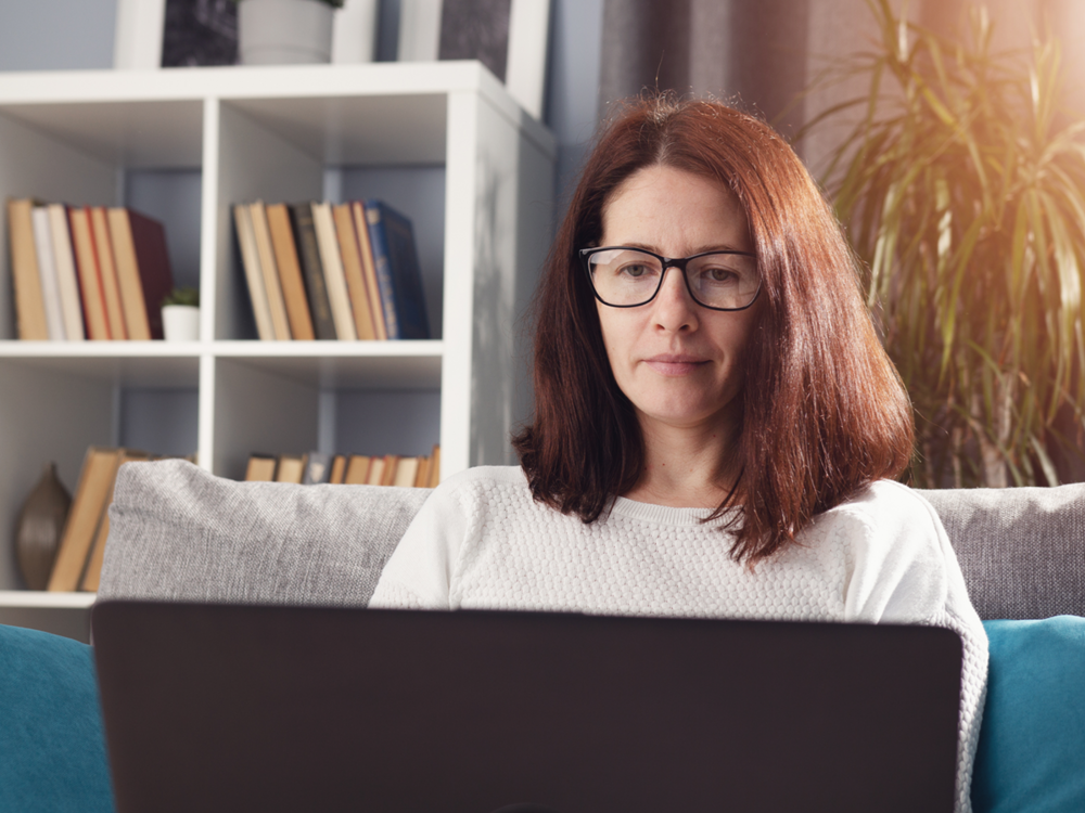 Kvinde med bærbar pc computer på sofa