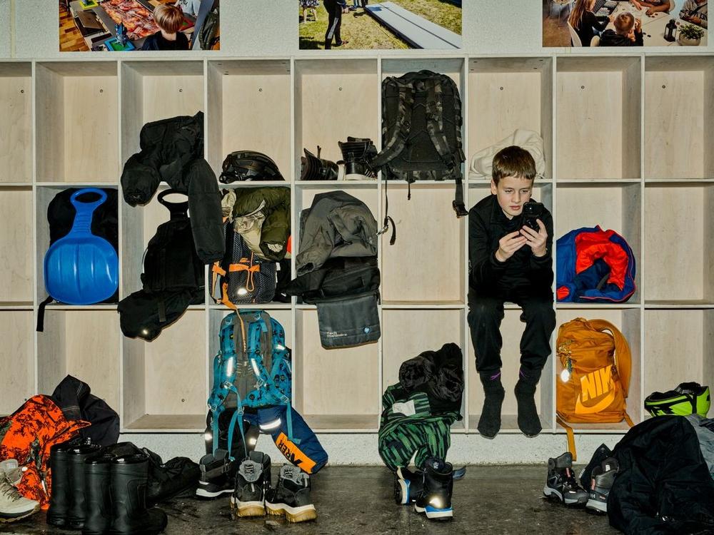 Dreng sidder alene i klub med sin telefon