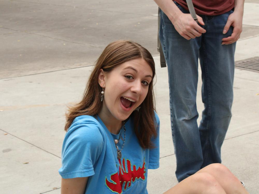 ung pige fra klub sidder på jorden og griner