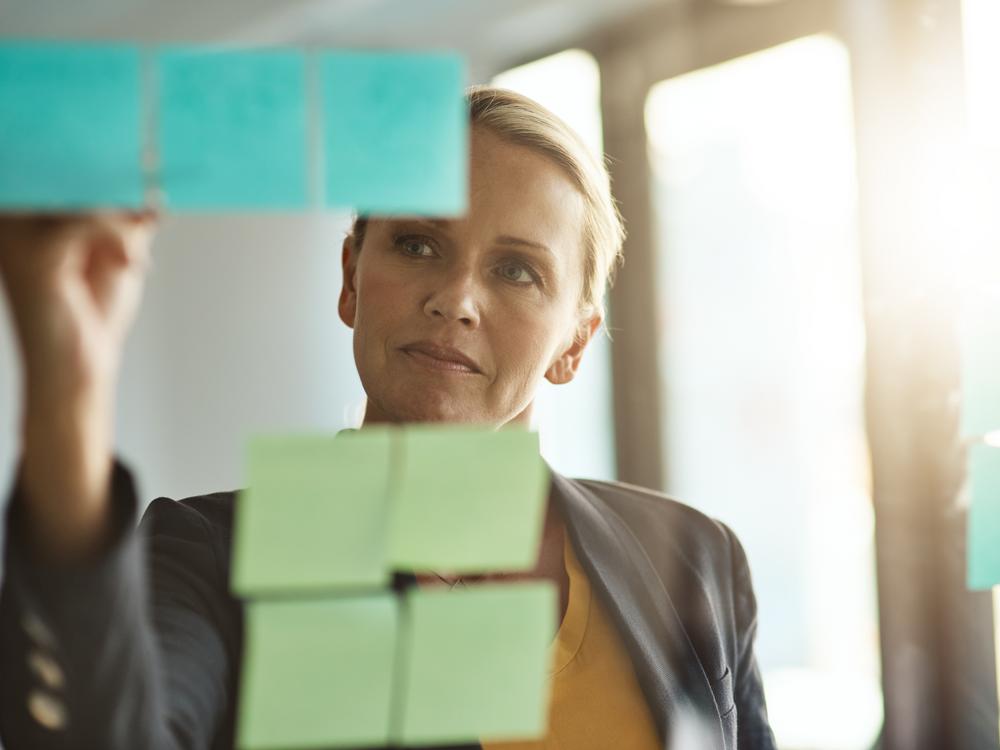 kvindelig leder og post-it-sedler; planlægger