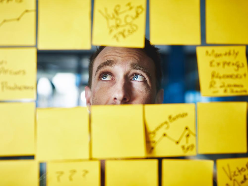 mandlig leder og mange gule post-it-sedler; for mange opgaver
