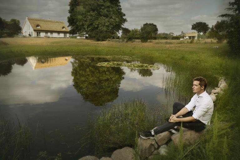 Jacob Mark sidder ved en sø